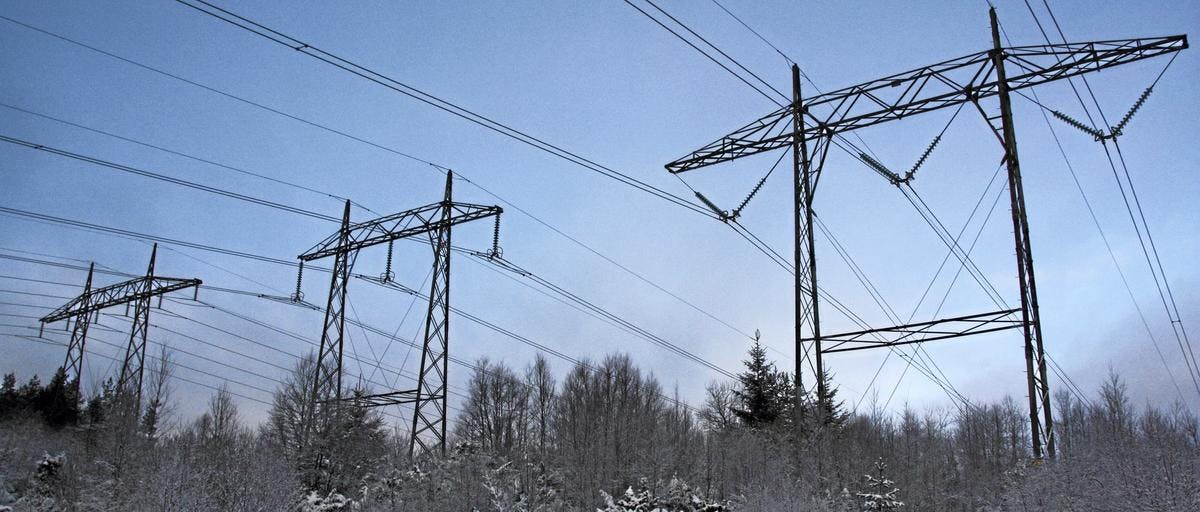 Bilde av tre store strømmaster i vinterlandskap